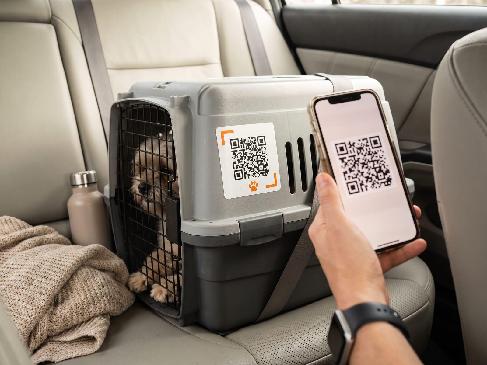 A pet travel crate on a car’s back seat with a square QR sticker on its side and a small dog inside.